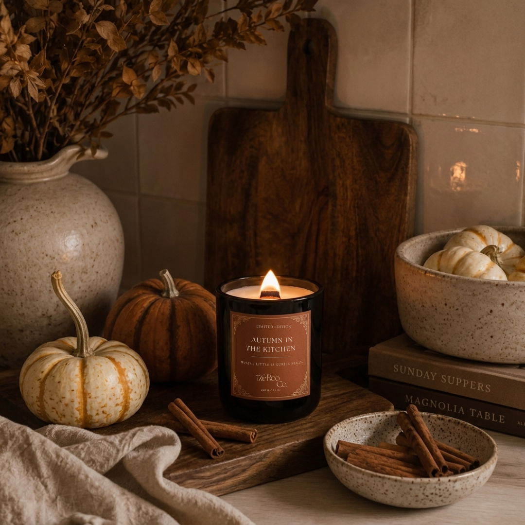 Autumn in the Kitchen candle burning in a warm autumn kitchen styled with pumpkins, cinnamon, cream ceramics, aged wood and linen.