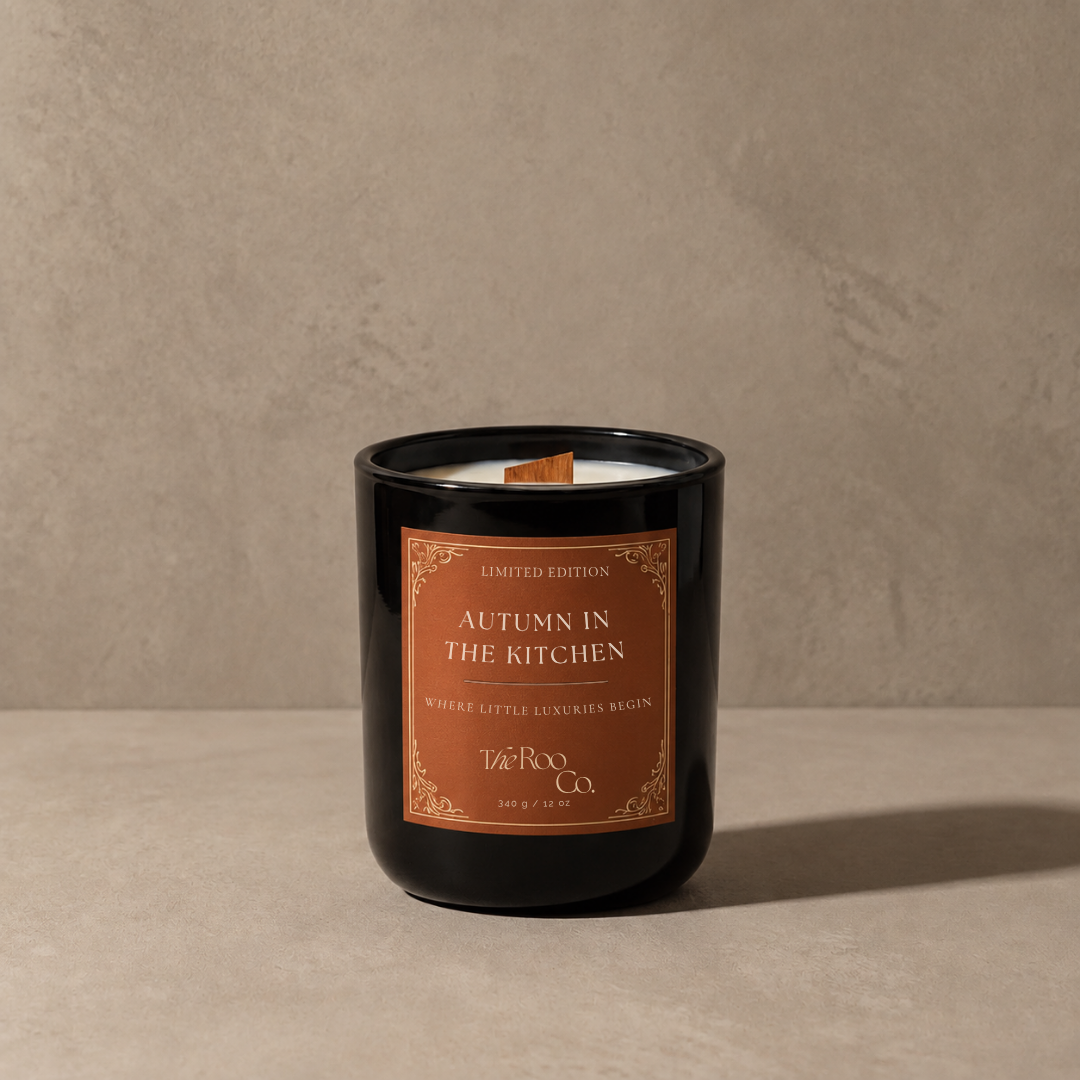 Autumn in the Kitchen luxury scented candle by The Roo Co in a glossy black glass vessel with a warm russet label.